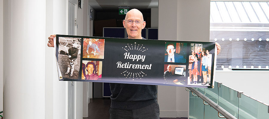 David Porteous holding retirement sign