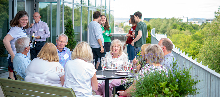 MRC Festival balcony image of chatting and drinks